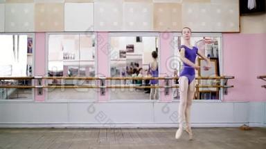 在舞厅里，穿着紫色紧身衣的年轻芭蕾舞演员在尖鞋上表演巡回<strong>演出</strong>，动作优雅，